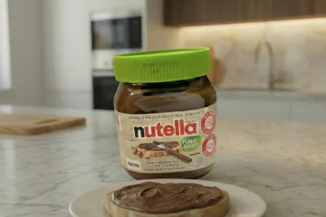 נוטלה צמחית ללא חלב ופרוסת לחם עם נוטלה על השיש במטבח