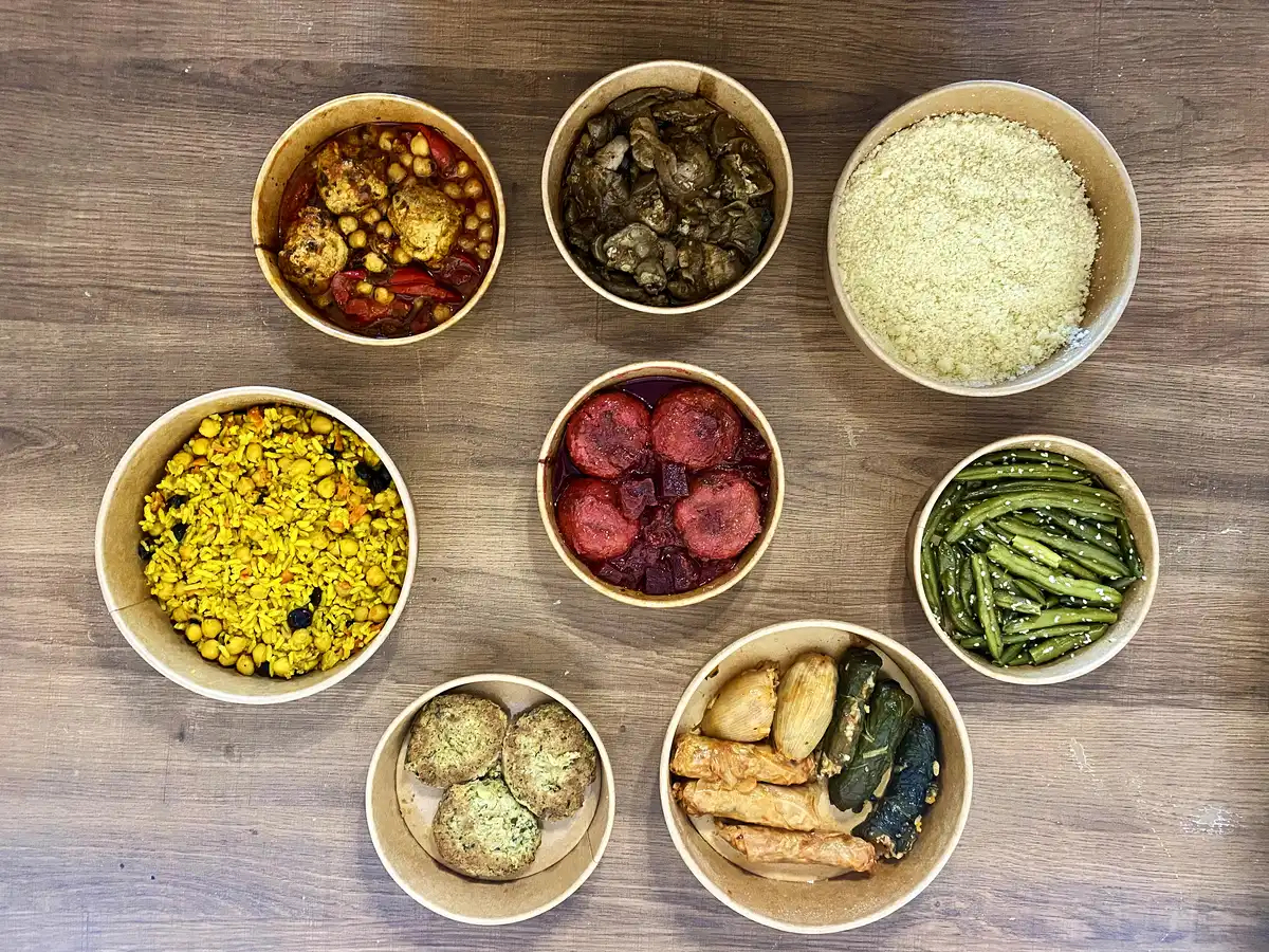 מנות אוכל מוכן בקופסאות פתוחות ממעדניית דאדי כולל קובה סלק, קוסקוס, שעועית וממולאים.